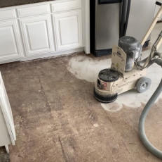 grinding thinset off of a floor in Bentonville AR to prepare it for new tile to be laid.
